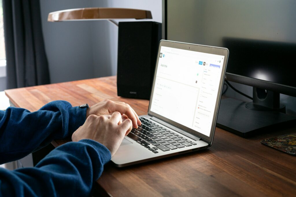 Symbolbild digitale Rechnungsstellung im Handwerk, Laptop mit Belegen auf Schreibtisch